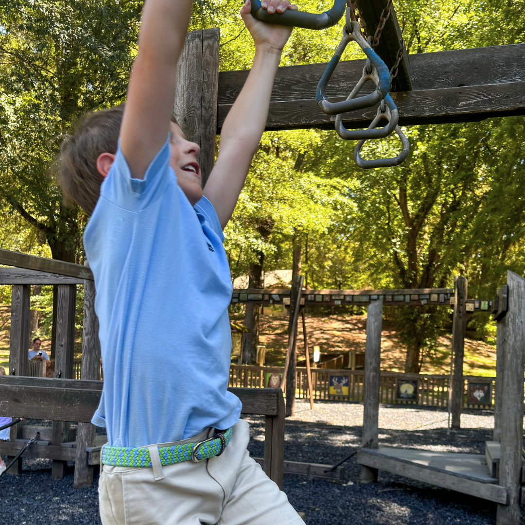 The Lil' Bermuda Kid's Woven Stretch Belt in motion on the monkey bars- 15% OFF SALE